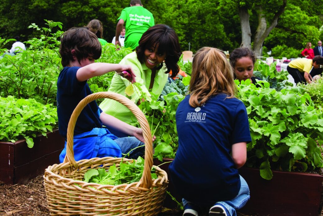 Michelle Obama tends her 1,100-square-foot South Lawn vegetable garden in the White House alongside some Elementary school students.