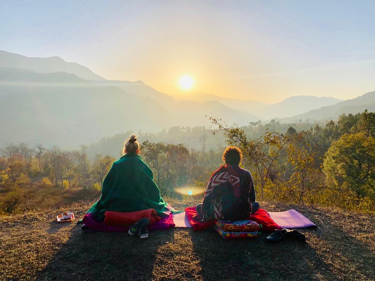 Silent retreat at White Light in Solan Himachal Pradesh with two people meditating in the Himalayan landscape at sunrise-